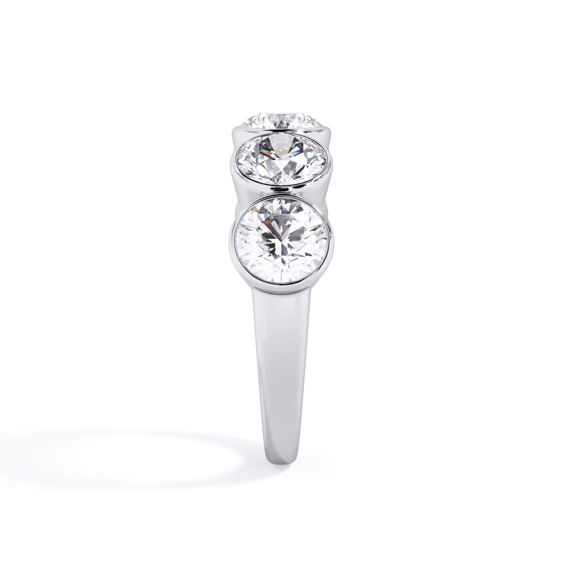 A picture of a five stone diamond wedding ring with round diamonds that are bezel set in white gold or platinum on a white background with a side profile view.