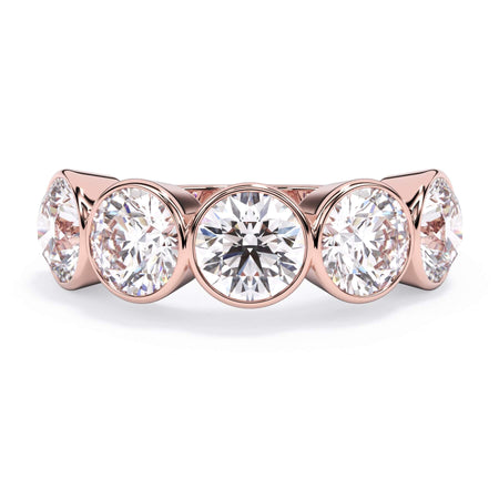 A picture of a five stone diamond wedding ring with round diamonds that are bezel set in rose gold on a white background with the ring facing forward, lying down.