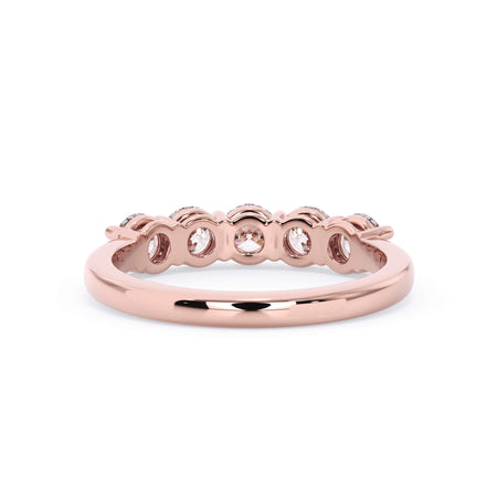 A picture of a five stone diamond wedding ring with round diamonds that are shared prong set in rose gold on a white background with a view of the underside of the ring.