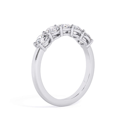 A picture of a five stone diamond wedding ring with round diamonds that are shared prong set in white gold or platinum on a white background with a slightly angled, through the finger view.