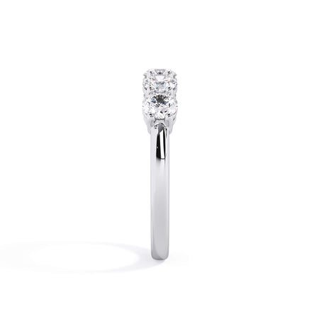 A picture of a five stone diamond wedding ring with round diamonds that are shared prong set in white gold or platinum on a white background with a side profile view.