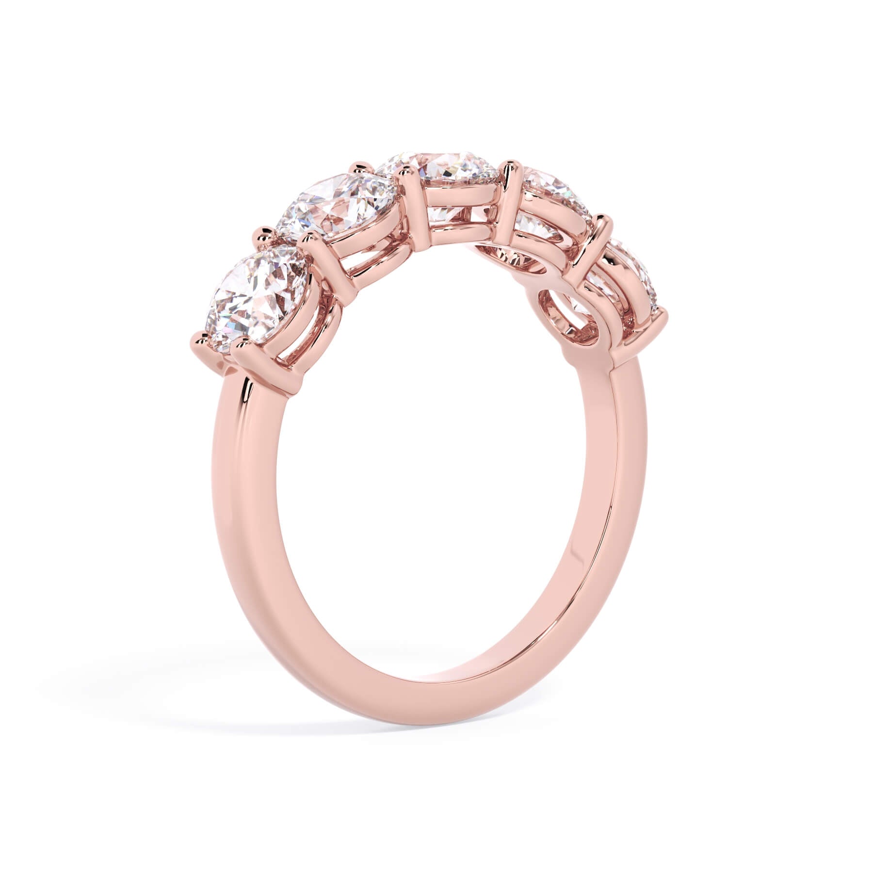 A picture of a five stone diamond wedding ring with round diamonds that are shared prong set in rose gold on a white background with a slightly angled, through the finger view.