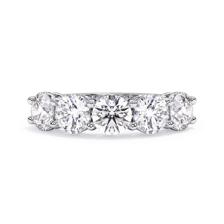 A picture of a five stone diamond wedding ring with round diamonds that are shared prong set in white gold or platinum on a white background with the ring facing forward, lying down.