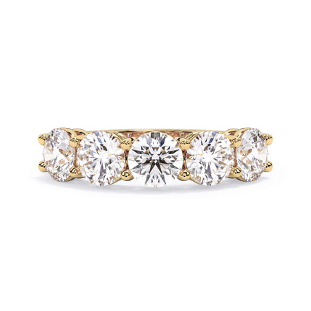 A picture of a five stone diamond wedding ring with round diamonds that are shared prong set in yellow gold on a white background with the ring facing forward, lying down.