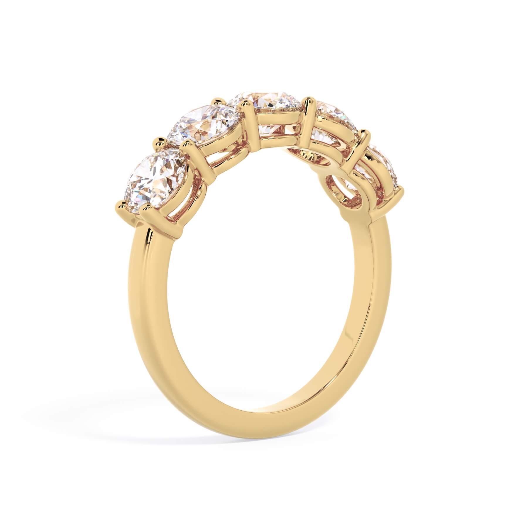 A picture of a five stone diamond wedding ring with round diamonds that are shared prong set in yellow gold on a white background with a slightly angled, through the finger view.