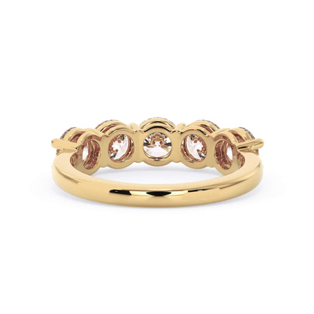A picture of a five stone diamond wedding ring with round diamonds that are shared prong set in yellow gold on a white background with a view of the underside of the ring.