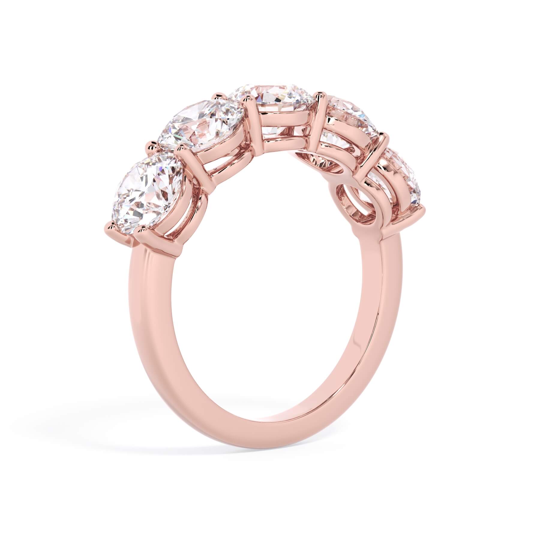 A picture of a five stone diamond wedding ring with round diamonds that are shared prong set in rose gold on a white background with a slightly angled, through the finger view.