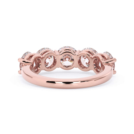 A picture of a five stone diamond wedding ring with round diamonds that are shared prong set in rose gold on a white background with a view of the underside of the ring.