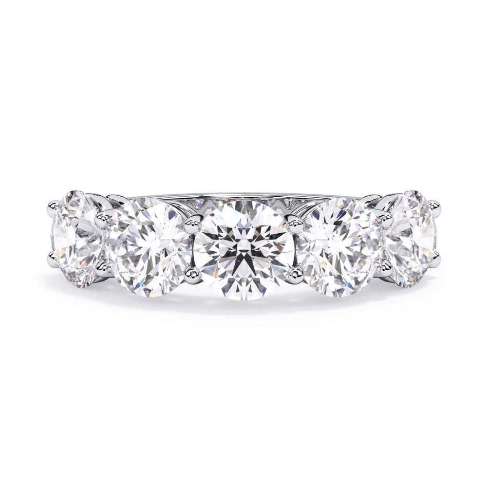 A picture of a five stone diamond wedding ring with round diamonds that are shared prong set in white gold or platinum on a white background with the ring facing forward, lying down.