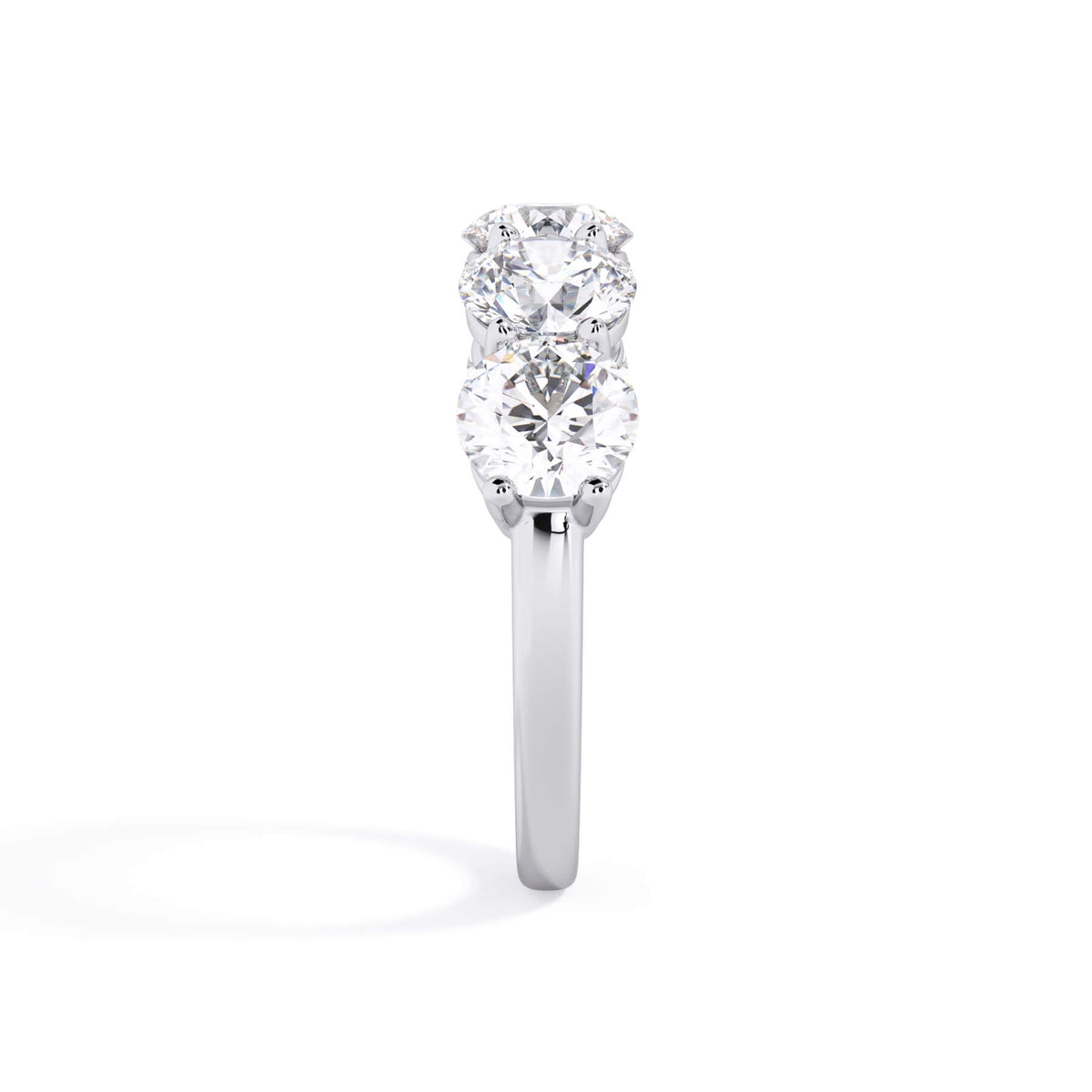 A picture of a five stone diamond wedding ring with round diamonds that are shared prong set in white gold or platinum on a white background with a side profile view.