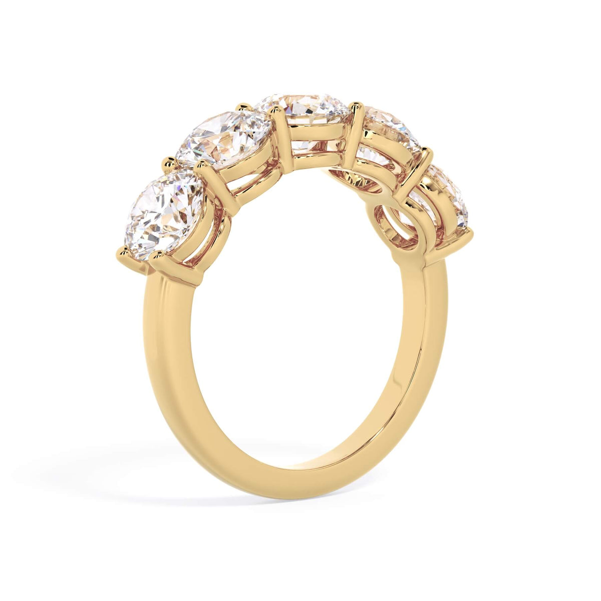 A picture of a five stone diamond wedding ring with round diamonds that are shared prong set in yellow gold on a white background with a slightly angled, through the finger view.