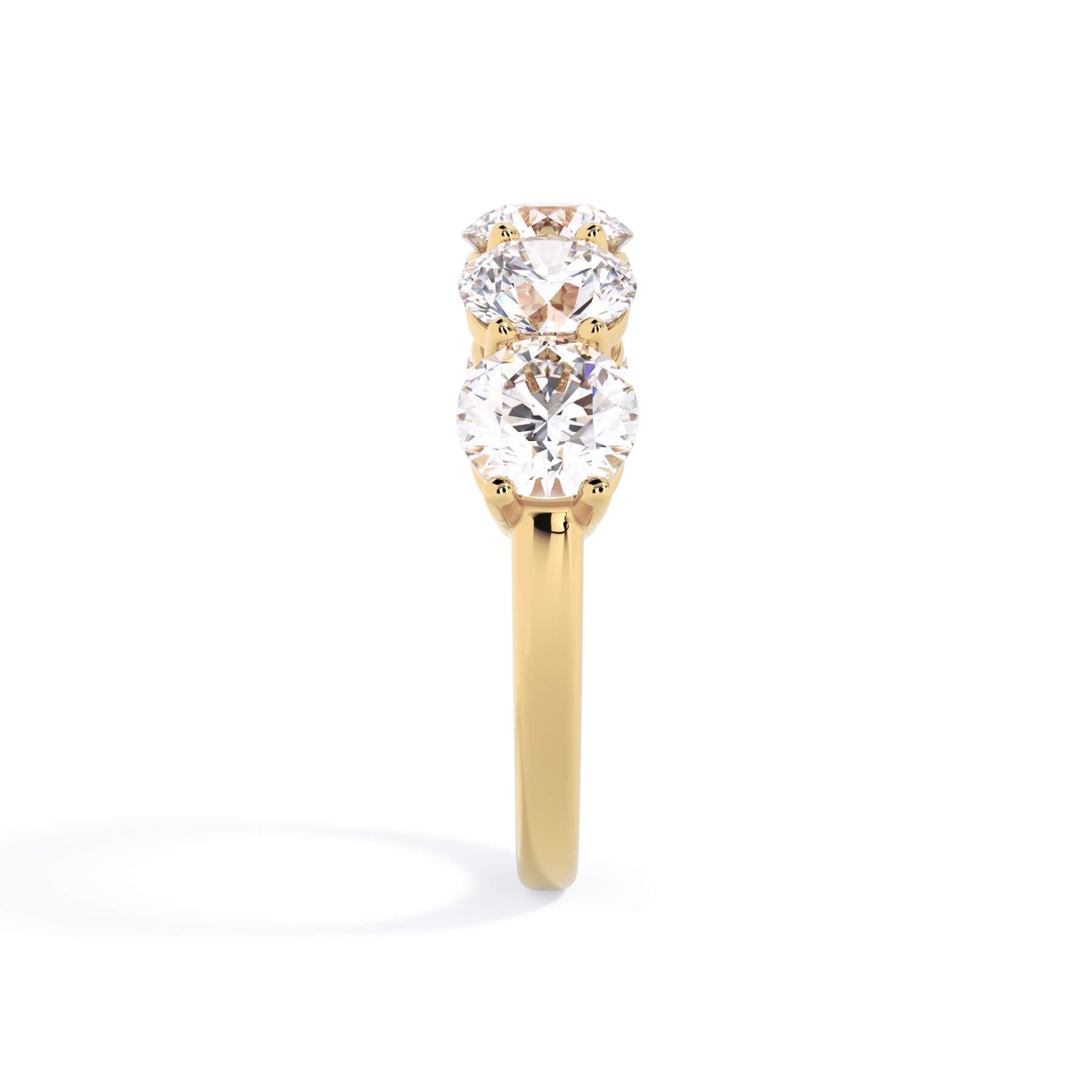 A picture of a five stone diamond wedding ring with round diamonds that are shared prong set in yellow gold on a white background with a side profile view.
