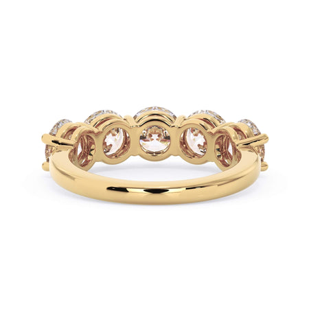 A picture of a five stone diamond wedding ring with round diamonds that are shared prong set in yellow gold on a white background with a view of the underside of the ring.