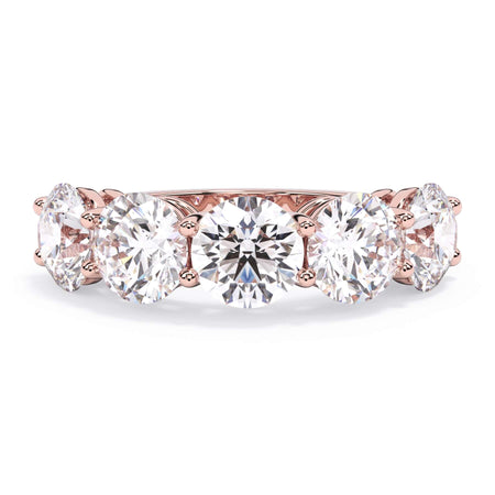 A picture of a five stone diamond wedding ring with round diamonds that are shared prong set in rose gold on a white background with the ring facing forward, lying down.