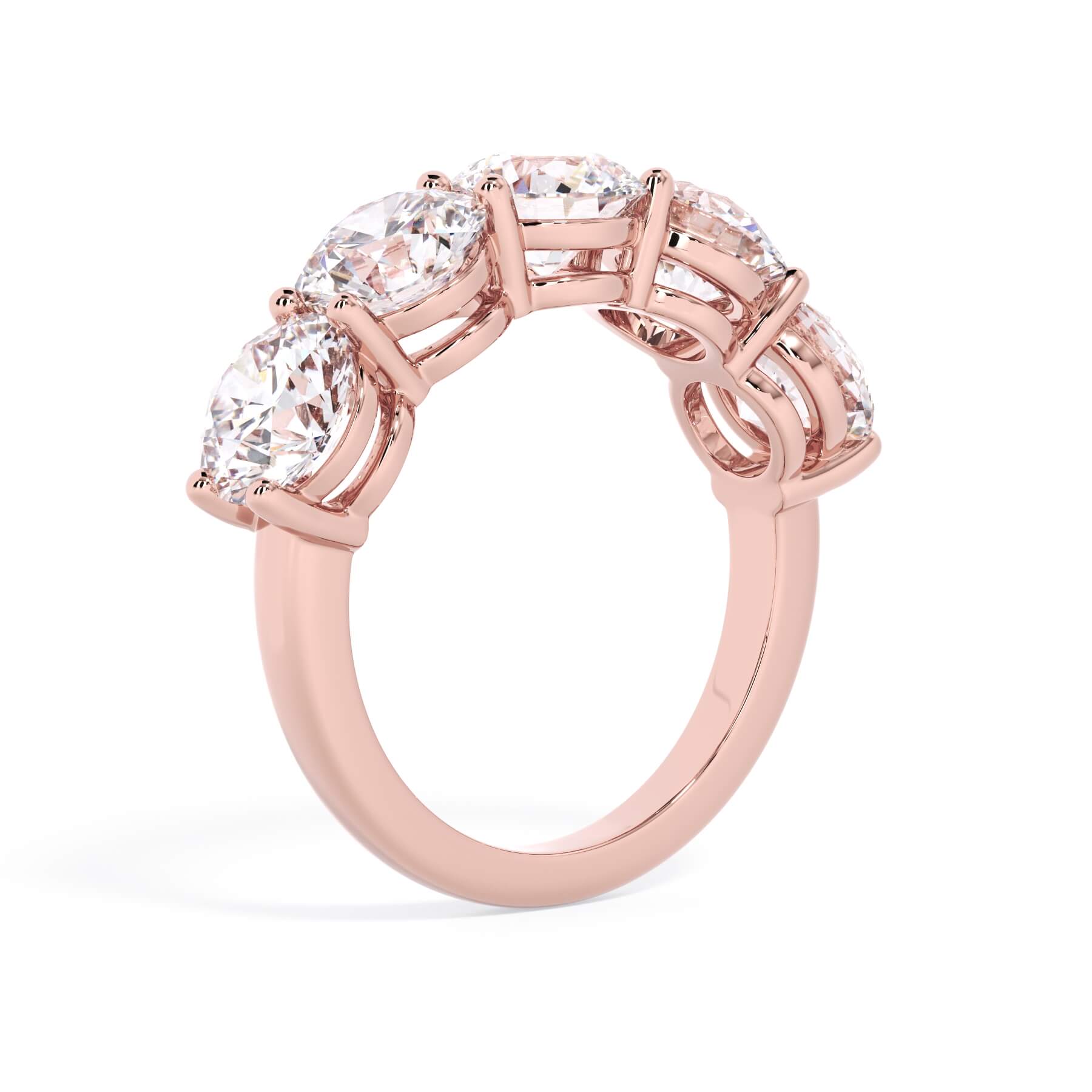 A picture of a five stone diamond wedding ring with round diamonds that are shared prong set in rose gold on a white background with a slightly angled, through the finger view.