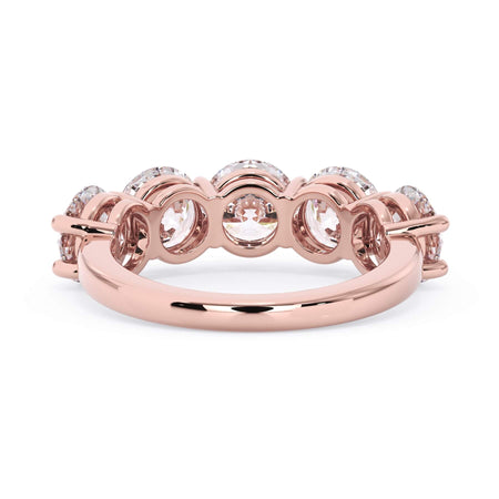 A picture of a five stone diamond wedding ring with round diamonds that are shared prong set in rose gold on a white background with a view of the underside of the ring.