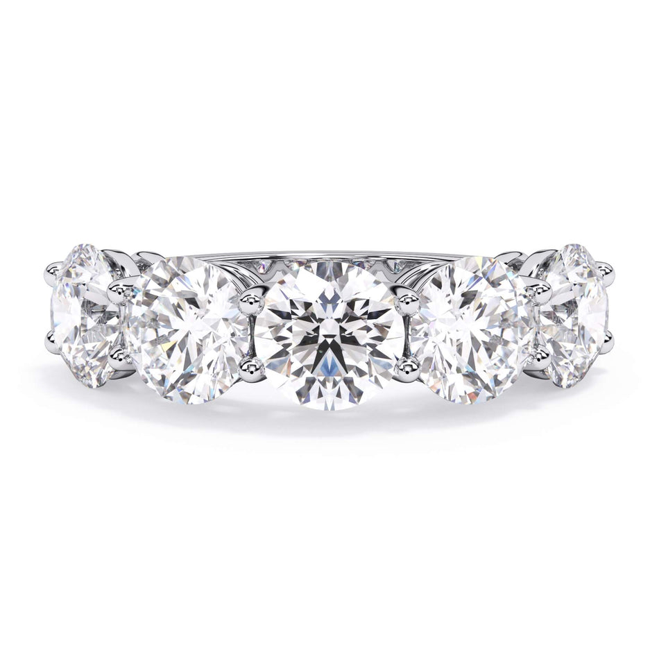 A picture of a five stone diamond wedding ring with round diamonds that are shared prong set in white gold or platinum on a white background with the ring facing forward, lying down.