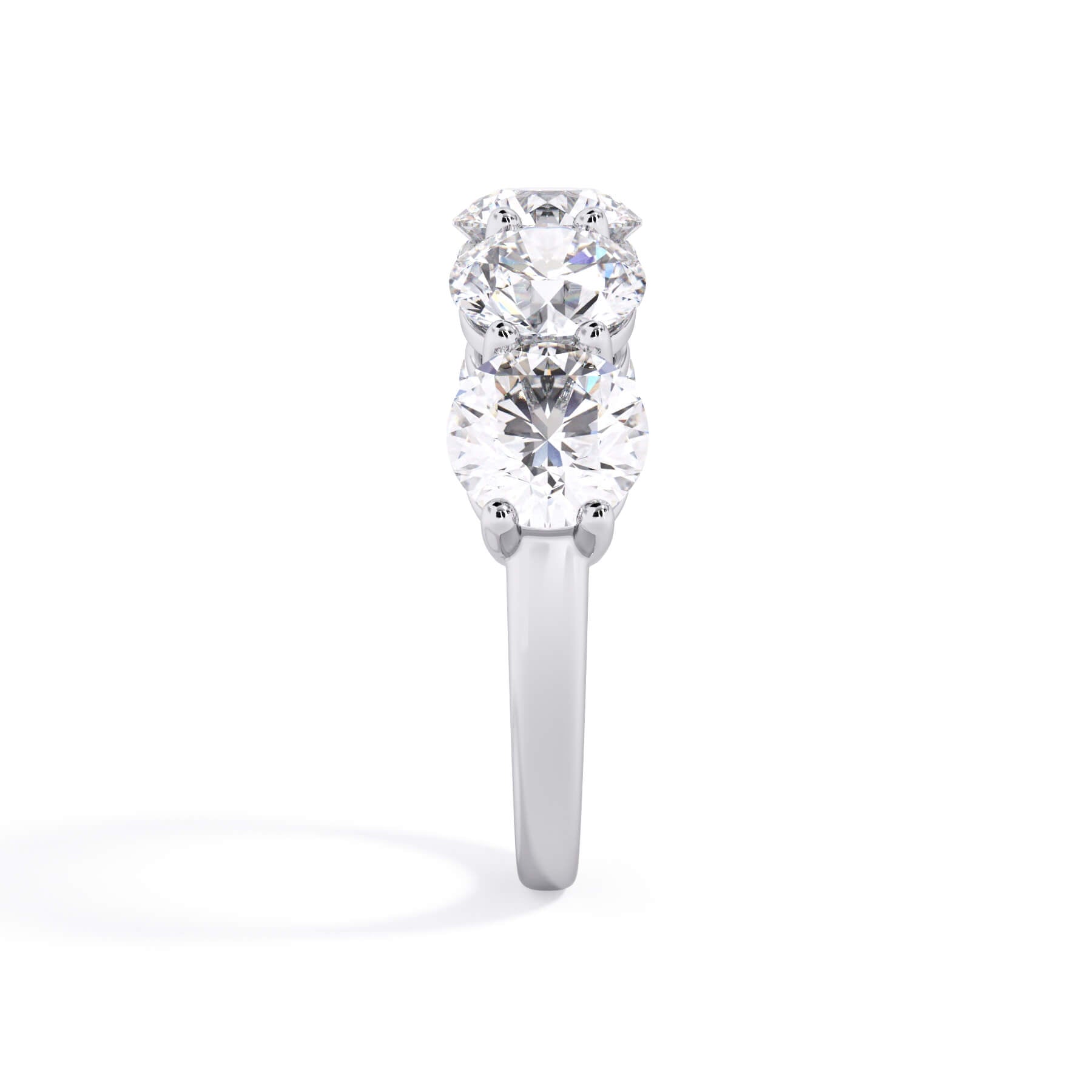 A picture of a five stone diamond wedding ring with round diamonds that are shared prong set in white gold or platinum on a white background with a side profile view.