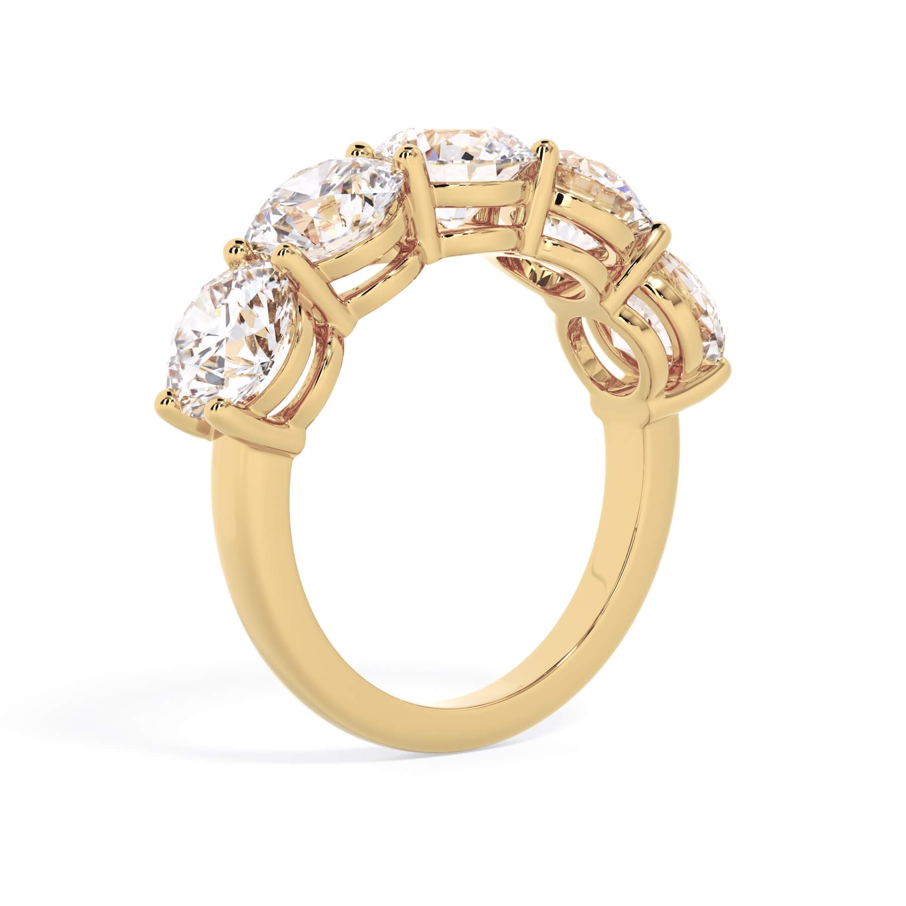 A picture of a five stone diamond wedding ring with round diamonds that are shared prong set in yellow gold on a white background with a slightly angled, through the finger view.