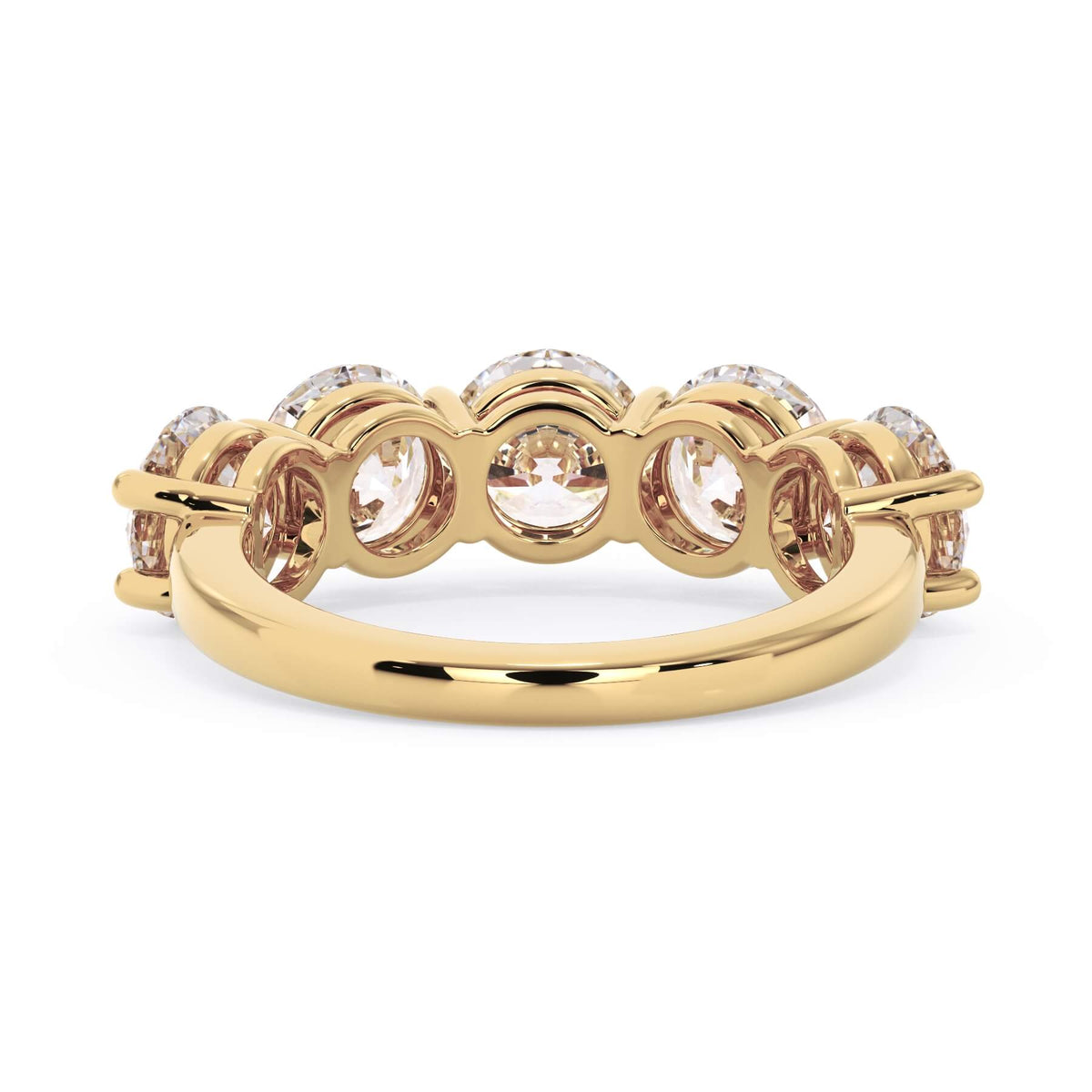 A picture of a five stone diamond wedding ring with round diamonds that are shared prong set in yellow gold on a white background with a view of the underside of the ring.