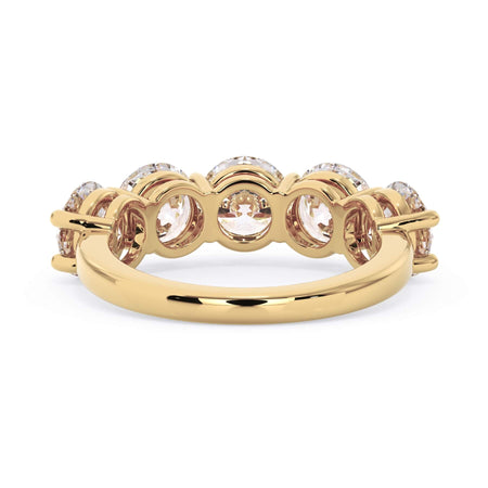 A picture of a five stone diamond wedding ring with round diamonds that are shared prong set in yellow gold on a white background with a view of the underside of the ring.