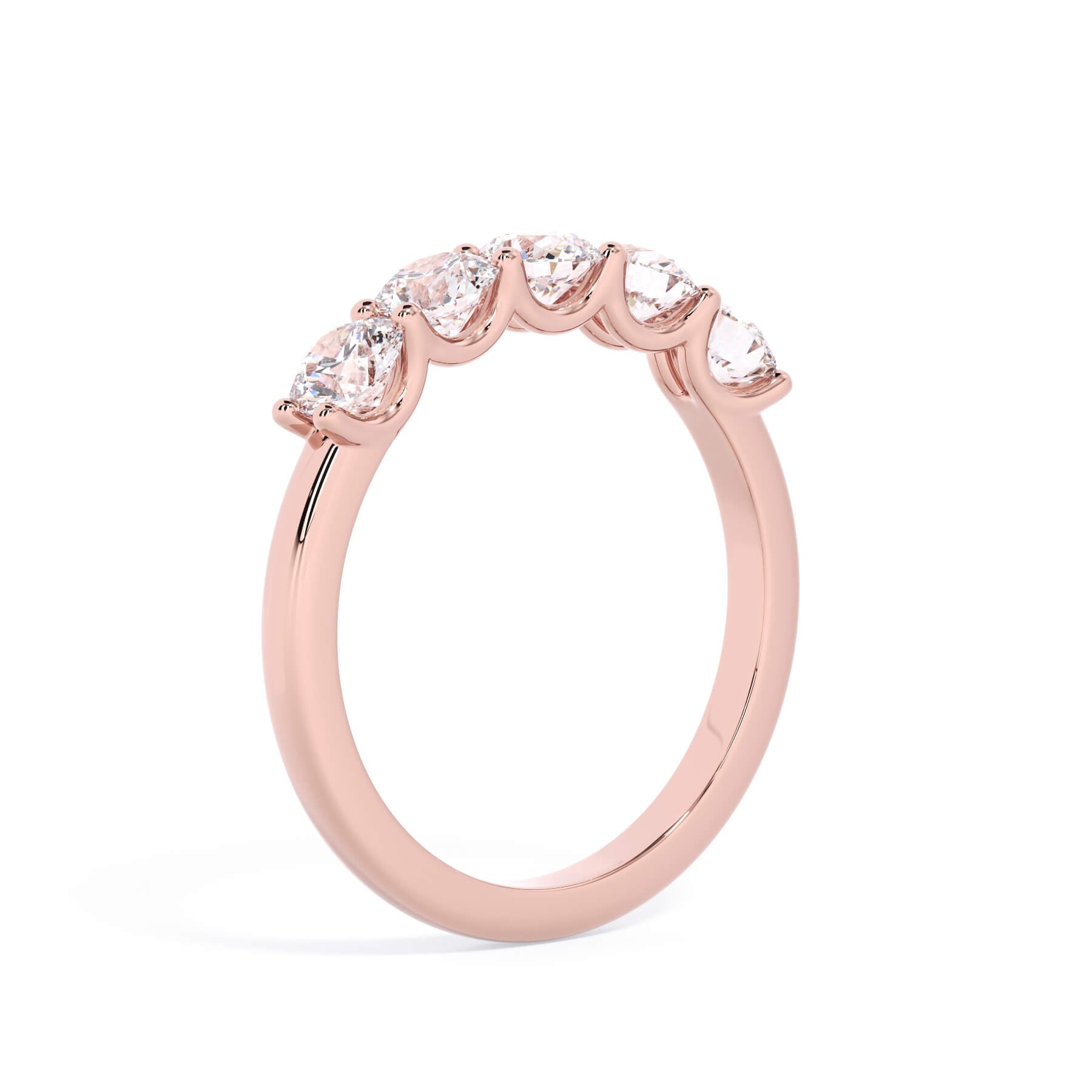 A picture of a five stone diamond wedding ring with round diamonds that are u prong set in rose gold on a white background with a slightly angled, through the finger view.