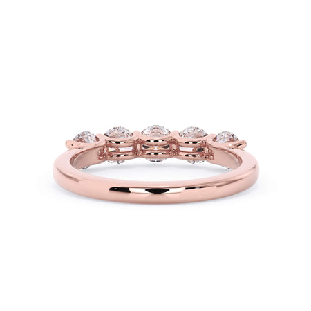 A picture of a five stone diamond wedding ring with round diamonds that are u prong set in rose gold on a white background with a view of the underside of the ring.