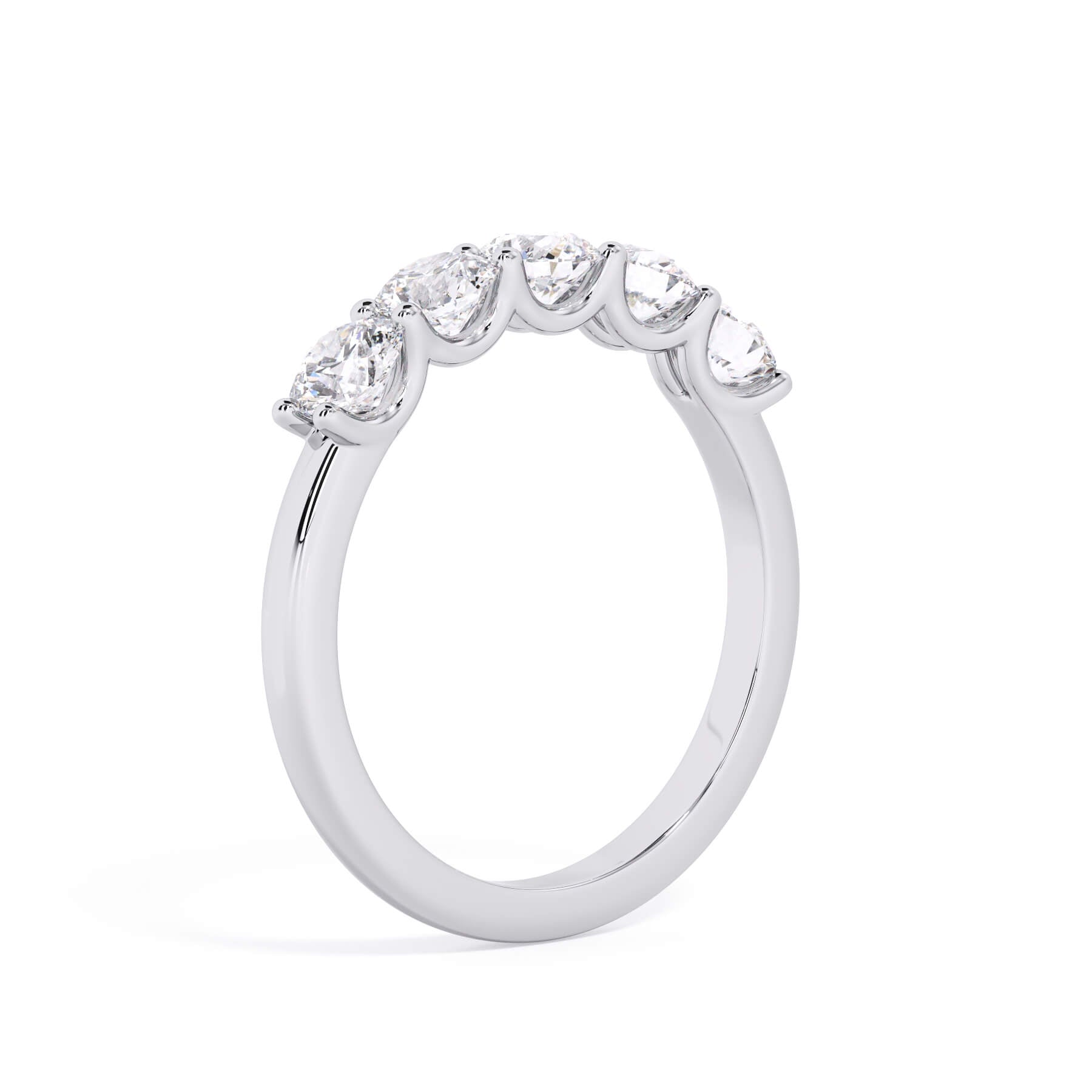 A picture of a five stone diamond wedding ring with round diamonds that are u prong set in white gold or platinum on a white background with a slightly angled, through the finger view.
