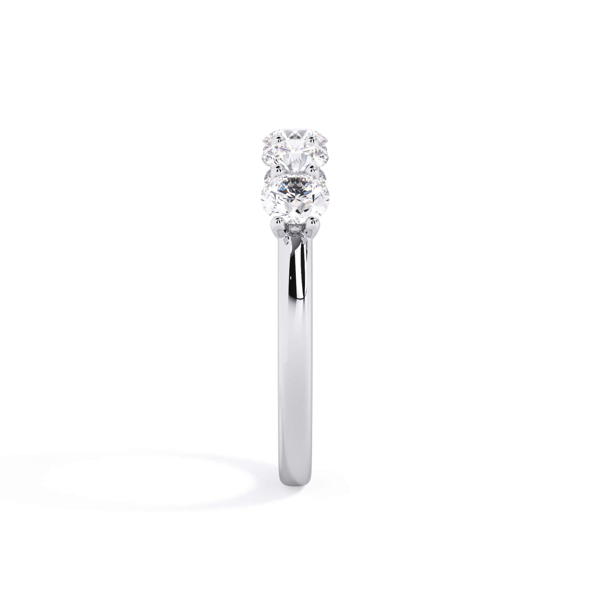 A picture of a five stone diamond wedding ring with round diamonds that are u prong set in white gold or platinum on a white background with a side profile view.