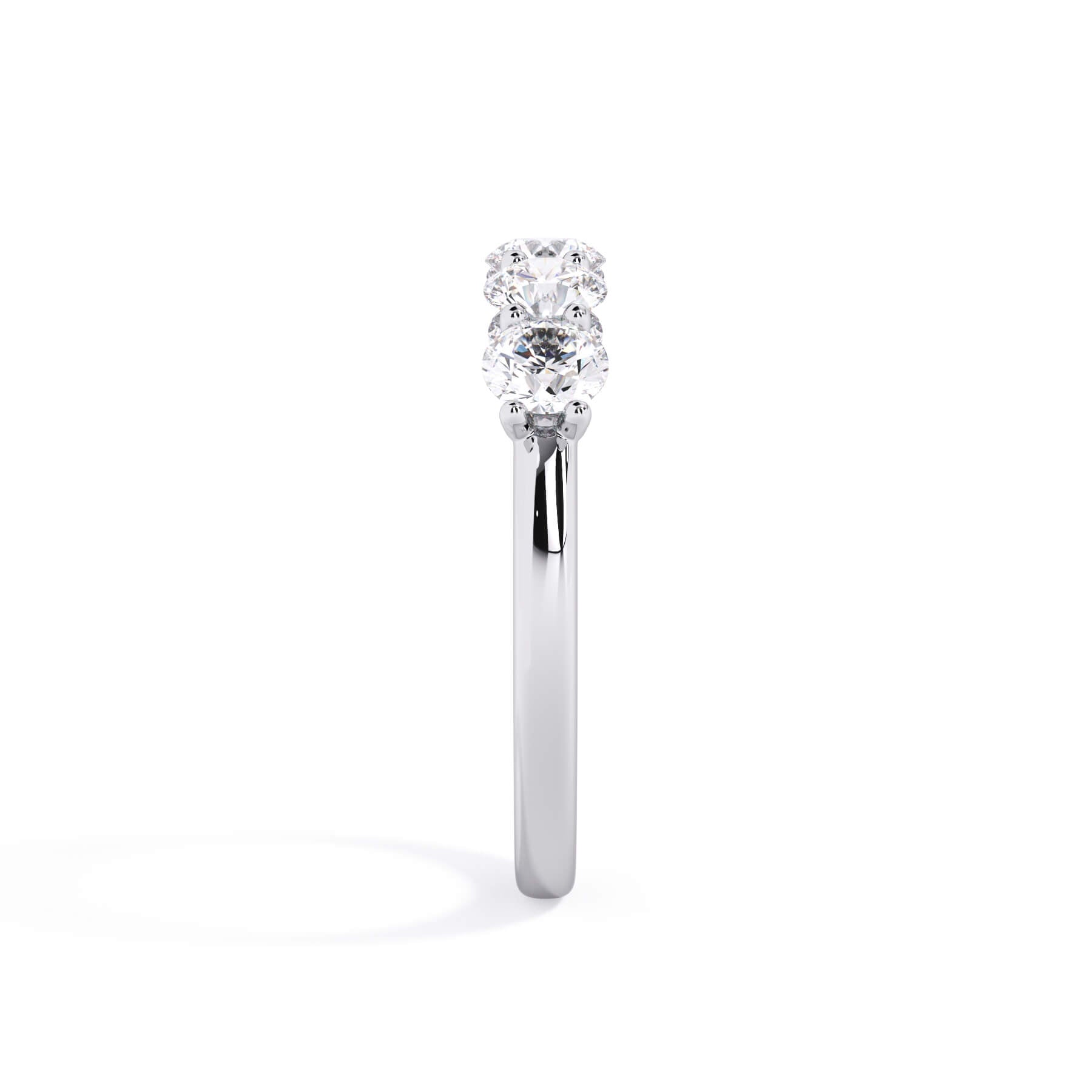 A picture of a five stone diamond wedding ring with round diamonds that are u prong set in white gold or platinum on a white background with a side profile view.