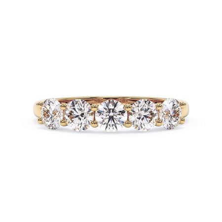 A picture of a five stone diamond wedding ring with round diamonds that are u prong set in yellow gold on a white background with the ring facing forward, lying down.