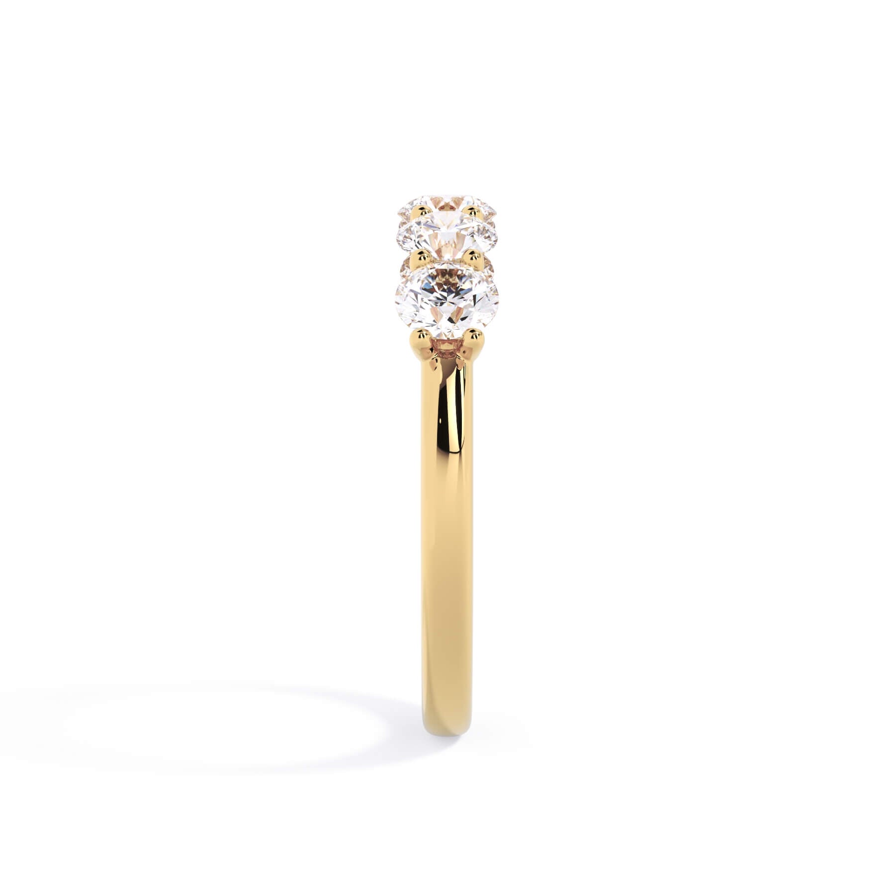 A picture of a five stone diamond wedding ring with round diamonds that are u prong set in yellow gold on a white background with a side profile view.