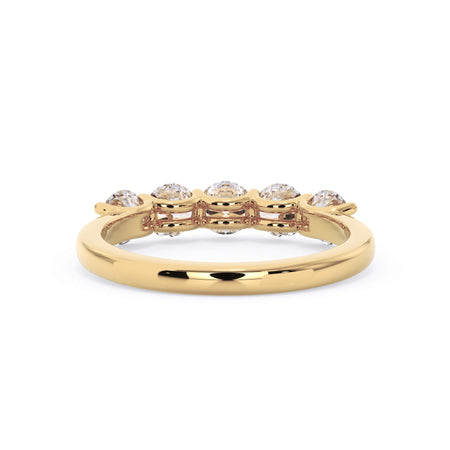 A picture of a five stone diamond wedding ring with round diamonds that are u prong set in yellow gold on a white background with a view of the underside of the ring.
