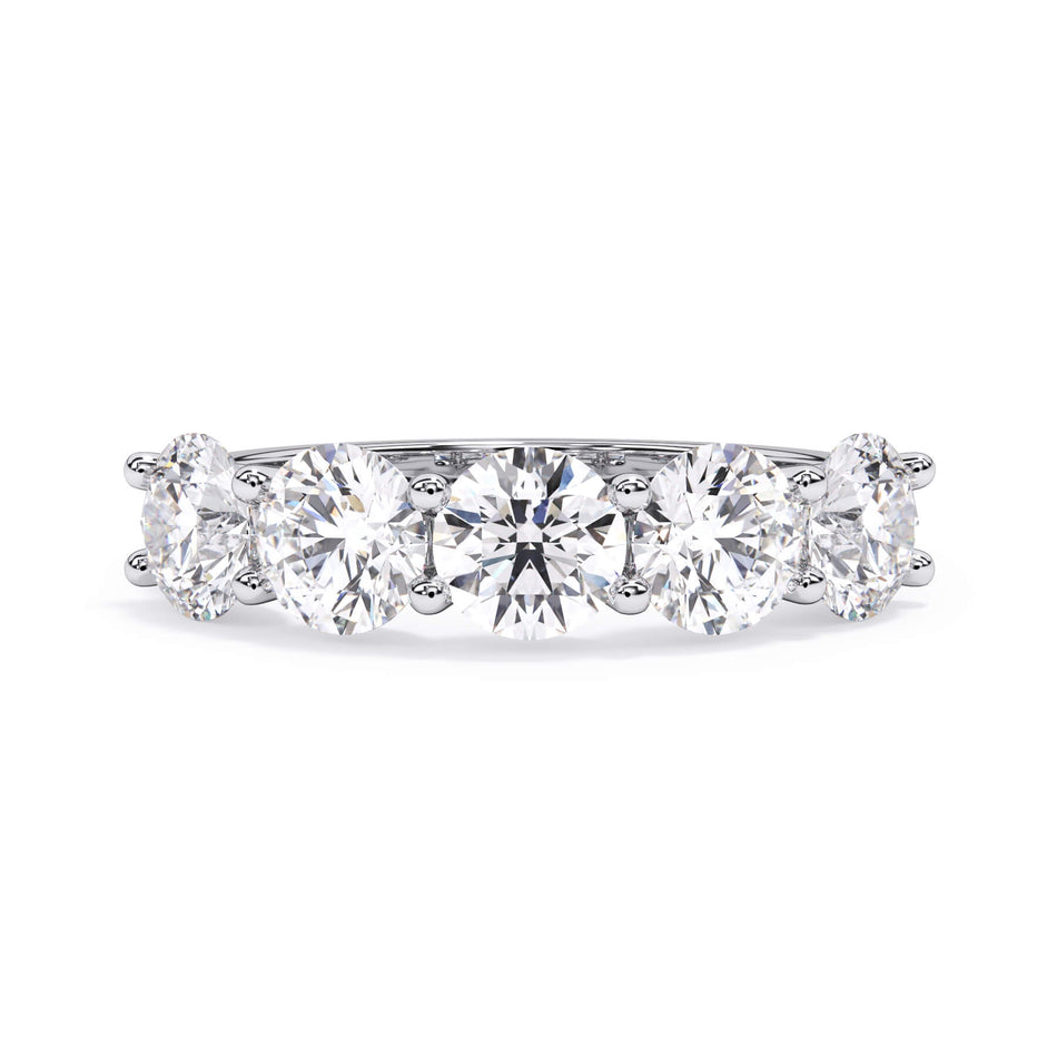 A picture of a five stone diamond wedding ring with round diamonds that are u prong set in white gold or platinum on a white background with the ring facing forward, lying down.