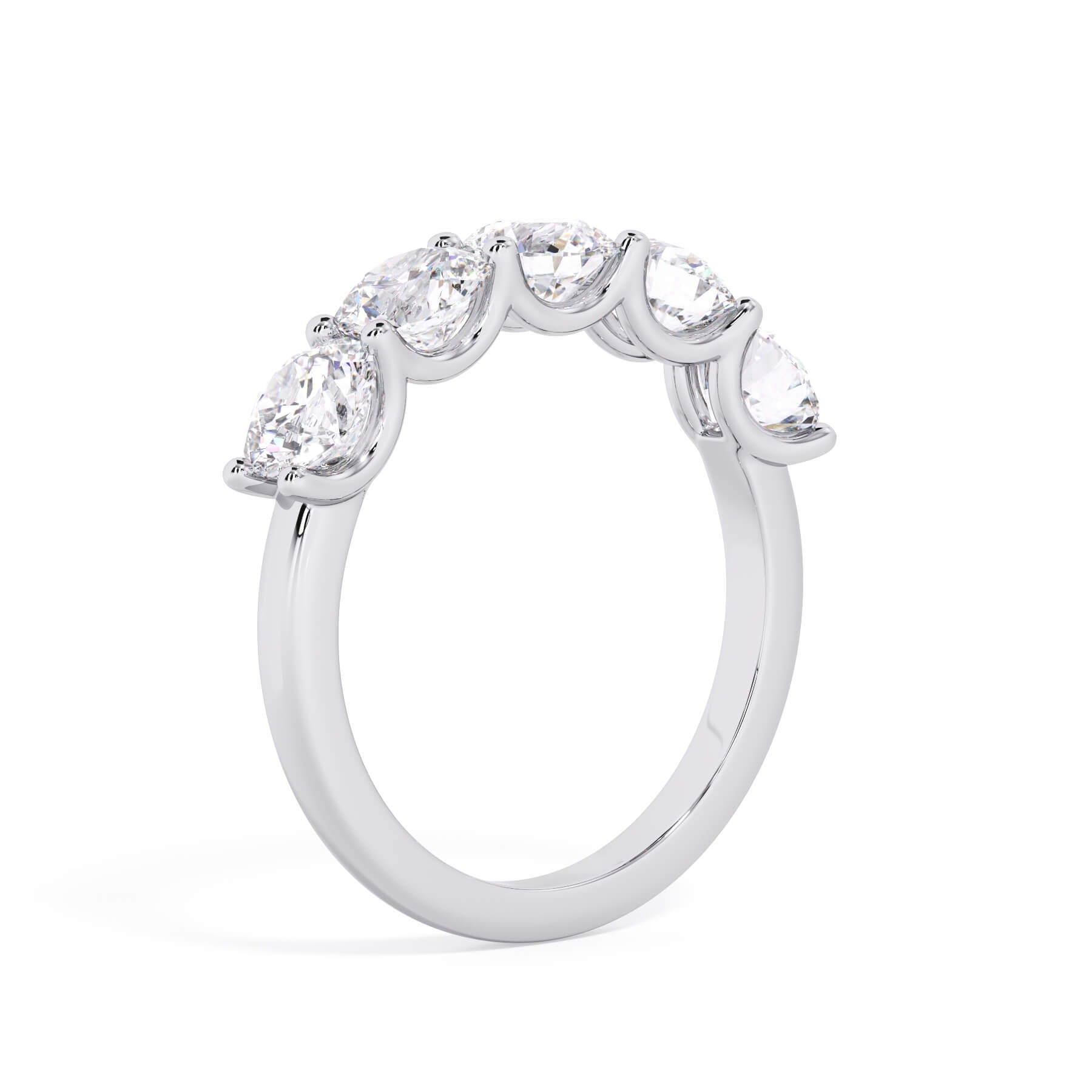 A picture of a five stone diamond wedding ring with round diamonds that are u prong set in white gold or platinum on a white background with a slightly angled, through the finger view.