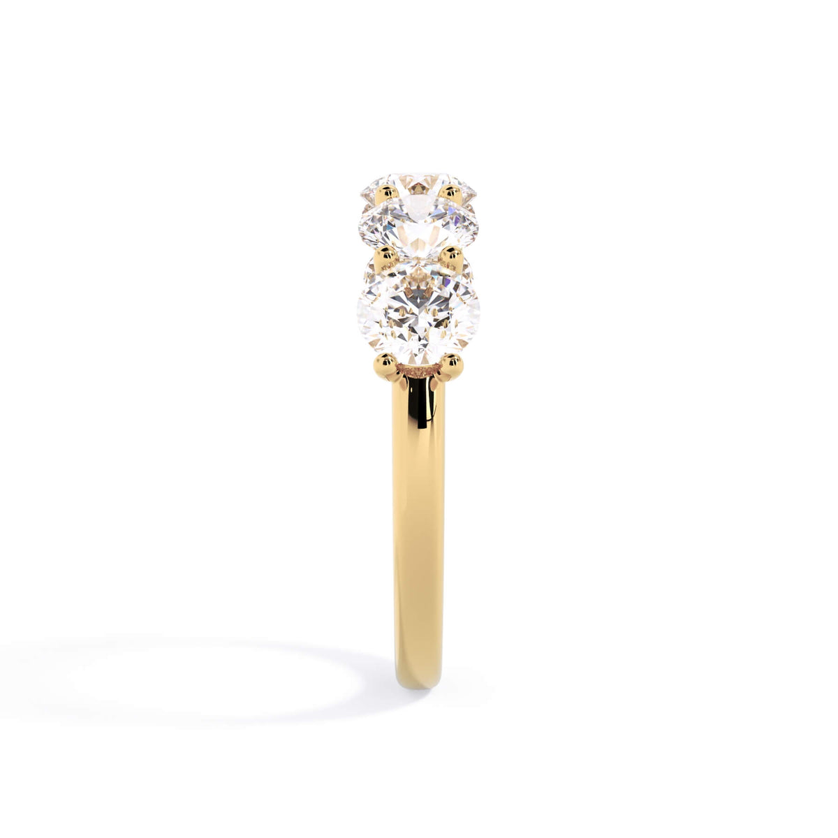 A picture of a five stone diamond wedding ring with round diamonds that are u prong set in yellow gold on a white background with a side profile view.
