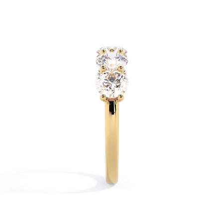 A picture of a five stone diamond wedding ring with round diamonds that are u prong set in yellow gold on a white background with a side profile view.