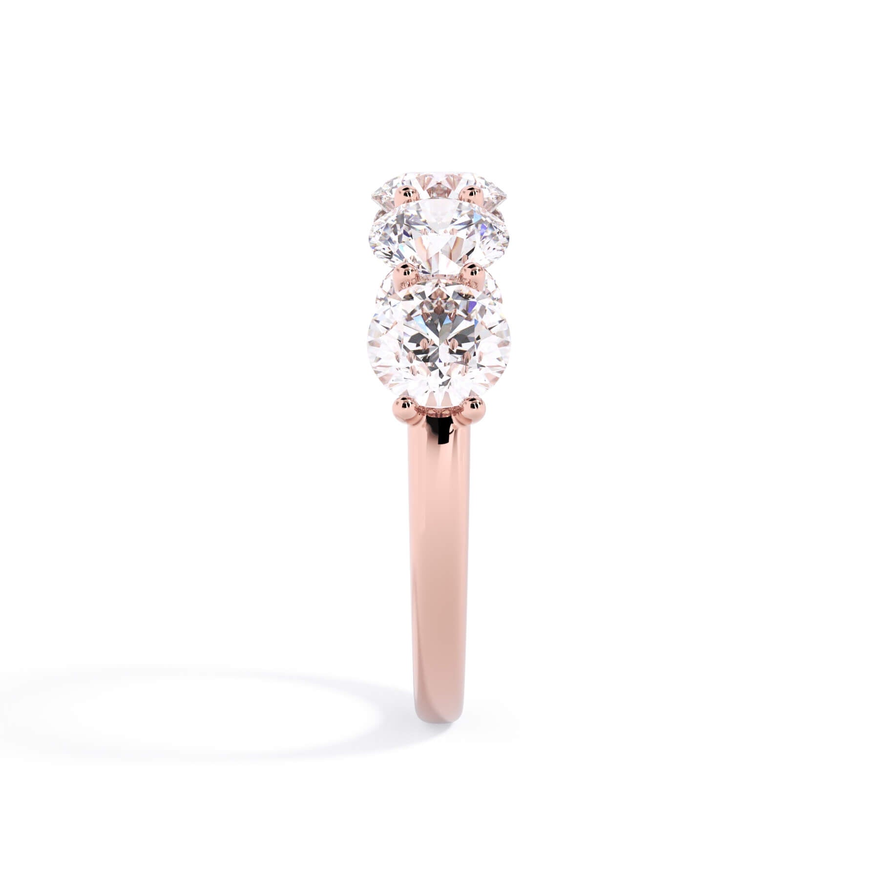 A picture of a five stone diamond wedding ring with round diamonds that are u prong set in rose gold on a white background with a side profile view.