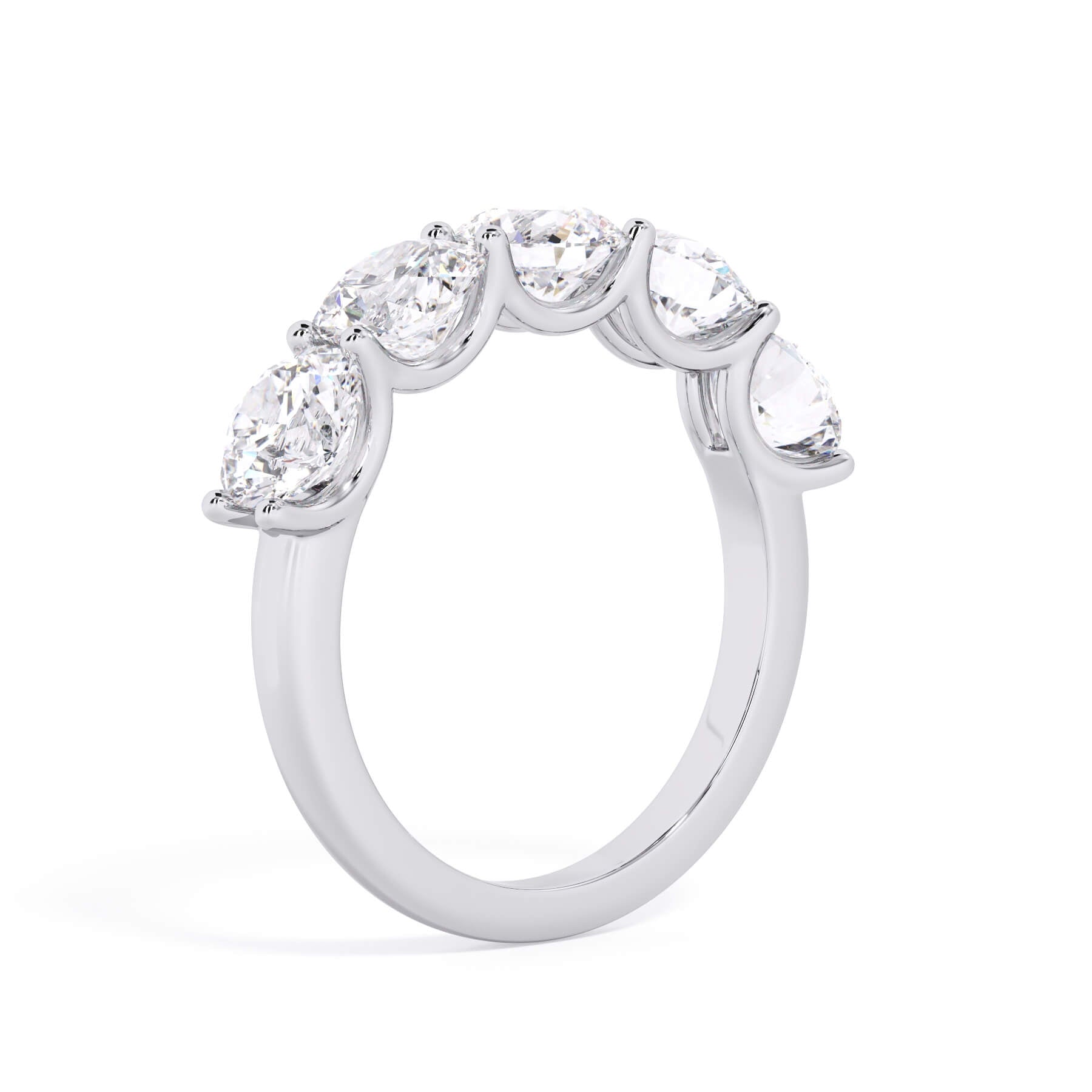 A picture of a five stone diamond wedding ring with round diamonds that are u prong set in white gold or platinum on a white background with a slightly angled, through the finger view.