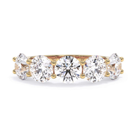 A picture of a five stone diamond wedding ring with round diamonds that are u prong set in yellow gold on a white background with the ring facing forward, lying down.