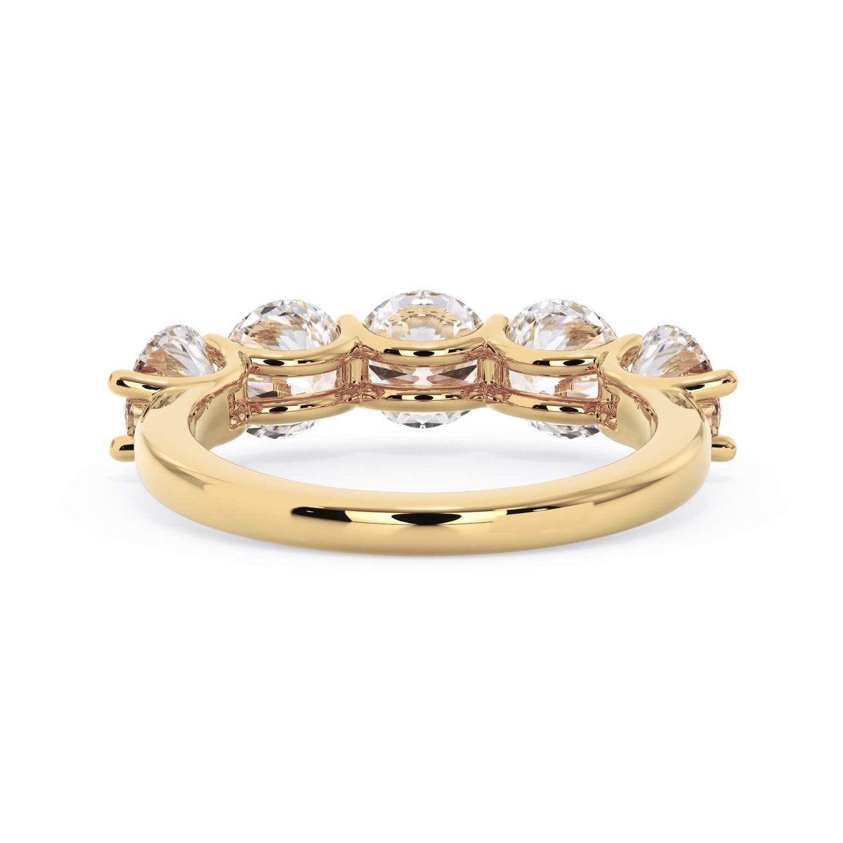 A picture of a five stone diamond wedding ring with round diamonds that are u prong set in yellow gold on a white background with a view of the underside of the ring.
