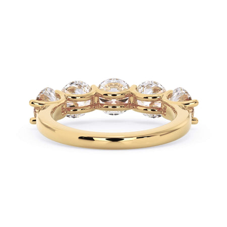 A picture of a five stone diamond wedding ring with round diamonds that are u prong set in yellow gold on a white background with a view of the underside of the ring.