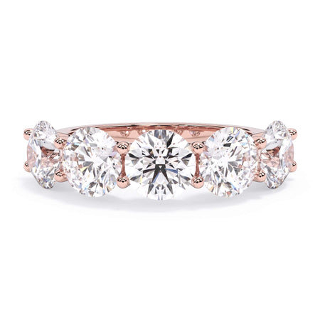 A picture of a five stone diamond wedding ring with round diamonds that are u prong set in rose gold on a white background with the ring facing forward, lying down.