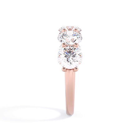 A picture of a five stone diamond wedding ring with round diamonds that are u prong set in rose gold on a white background with a side profile view.