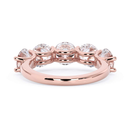 A picture of a five stone diamond wedding ring with round diamonds that are u prong set in rose gold on a white background with a view of the underside of the ring.