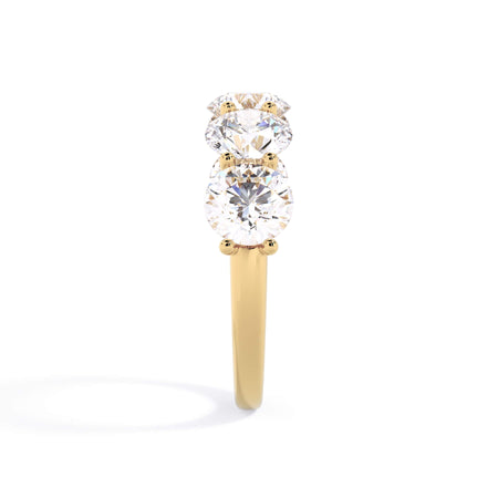 A picture of a five stone diamond wedding ring with round diamonds that are u prong set in yellow gold on a white background with a side profile view.