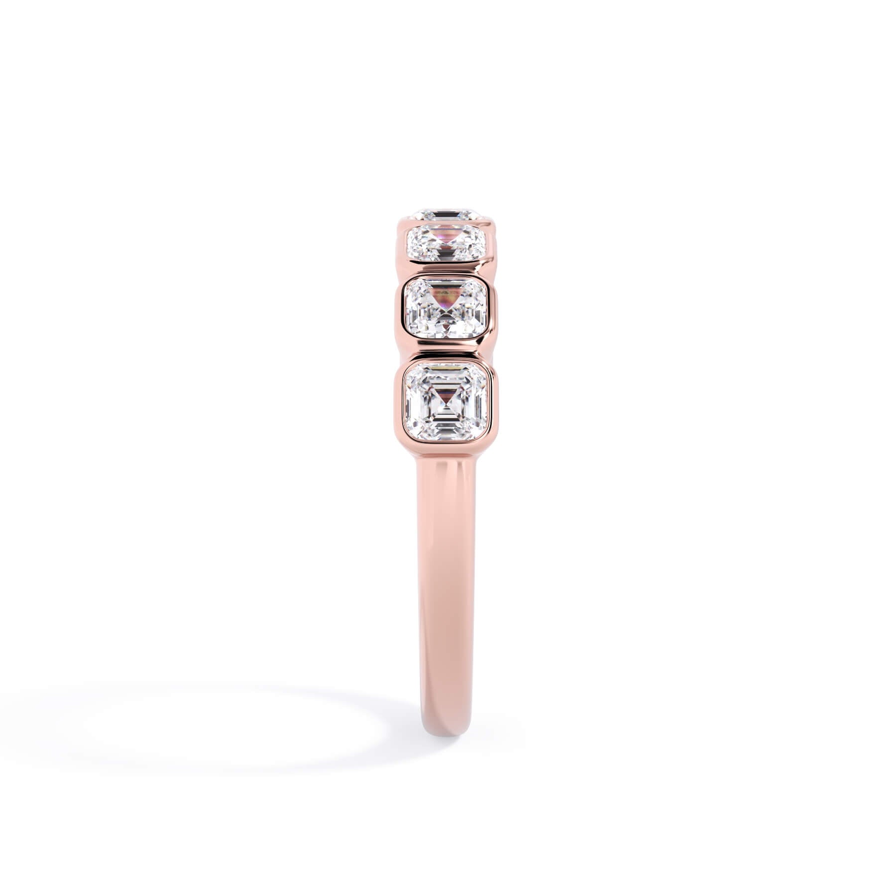 A picture of a seven stone diamond wedding ring with asscher cut diamonds that are bezel set in rose gold on a white background with a side profile view.