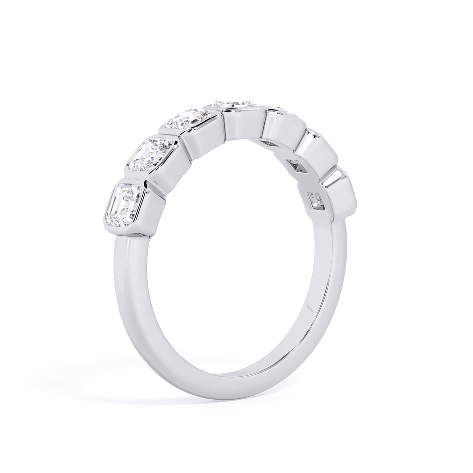 A picture of a seven stone diamond wedding ring with asscher cut diamonds that are bezel set in white gold or platinum on a white background with a slightly angled, through the finger view.