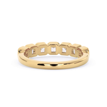 A picture of a seven stone diamond wedding ring with asscher cut diamonds that are bezel set in yellow gold on a white background with a view of the underside of the ring.