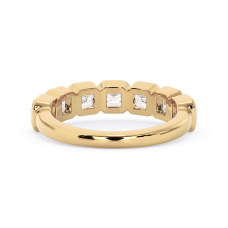 A picture of a seven stone diamond wedding ring with asscher cut diamonds that are bezel set in yellow gold on a white background with a view of the underside of the ring.